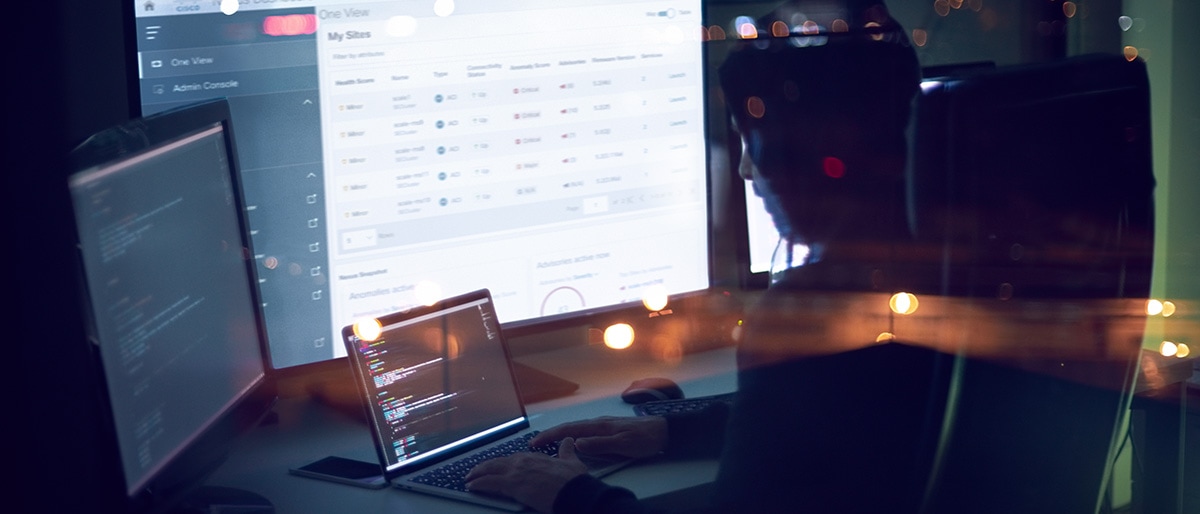 A person working across multiple screens to manage the network using Cisco Catalyst software