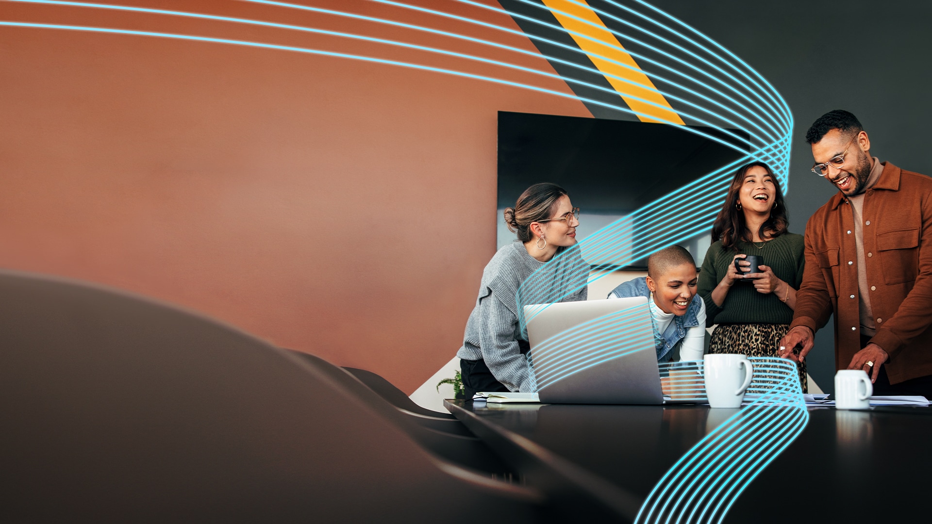 A group of people laughing, drinking coffee, and looking at a computer in an office